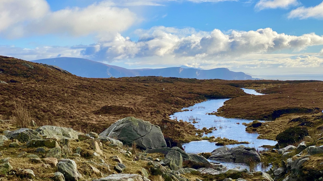 Rocky bogland stream with distant Achill mountains and Atlantic light