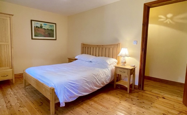 Double bedroom with wooden furniture and bedside lamp