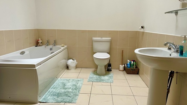 Apartment bathroom with bath, toilet and sink