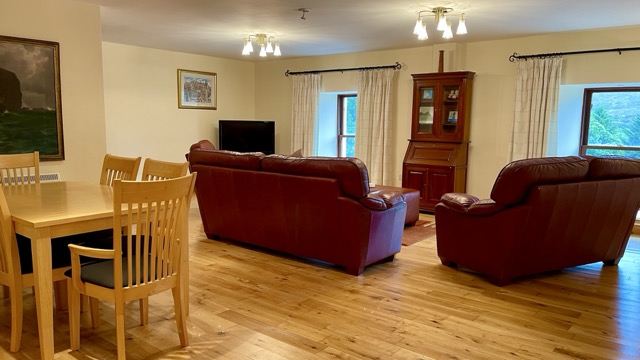 Apartment sitting room with red sofas and dining area
