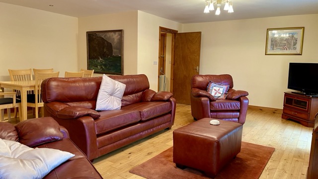 Sitting room with red leather sofas and television