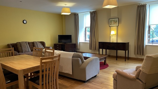 Warm open-plan living and dining room with tall windows