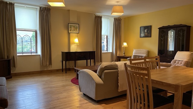 Wide living room with yellow feature wall and dining area