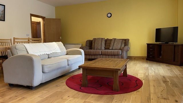 Living room with cream sofa, coffee table and television