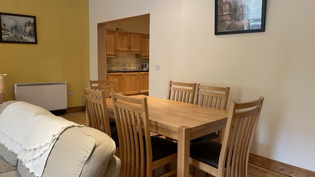 Dining area beside sofa with kitchen through the opening