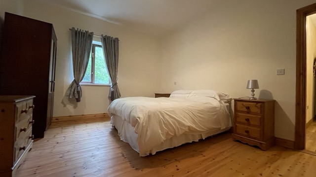 Double bedroom with window, wooden floor and wardrobe