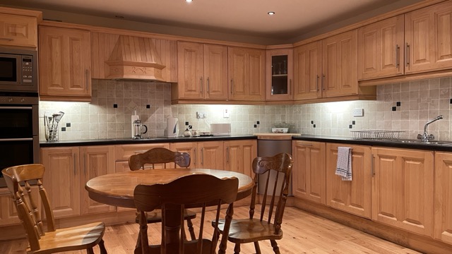 Large fitted kitchen with round dining table