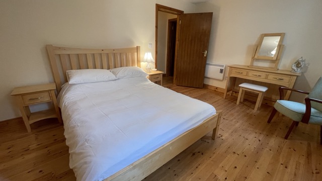 Double bedroom with dressing table and wooden floor