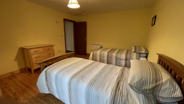 Twin beds with striped bedding in a warm bedroom