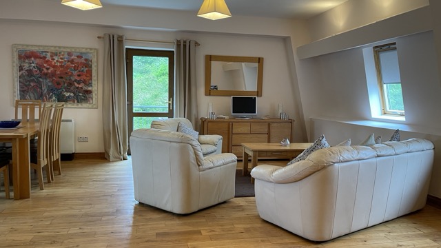 Open-plan living room with cream sofas and dining area