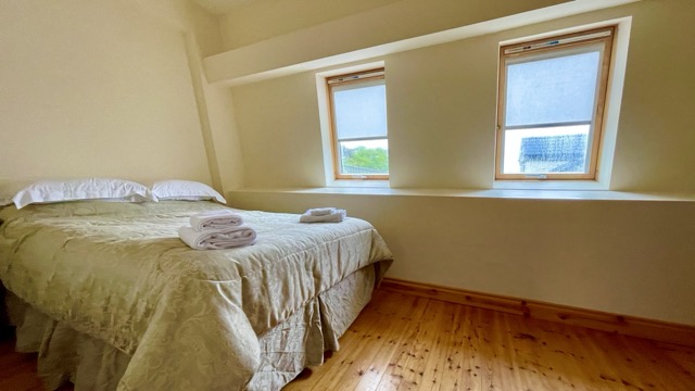 Double bedroom with towels and deep-set windows
